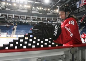 ST. CATHARINES, CANADA - JANUARY 09: Switzerland's Kaleigh Quennec #18 prepares to knock down a stack of pucks in the warmup prior to preliminary round action against Team Finland at the 2016 IIHF Ice Hockey U18 Women's World Championship. (Photo by Francois Laplante/HHOF-IIHF Images)


